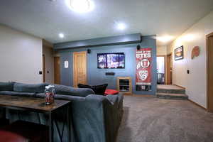 Carpeted living area with a textured ceiling and stairway