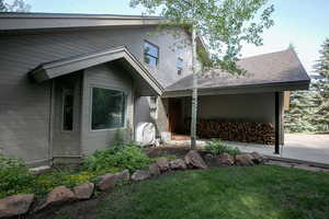 View of front of home with a shingled roof, oil tank, and a front lawn