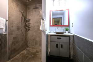 Bathroom featuring a tile shower and vanity