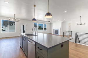 Kitchen with a chandelier, recessed lighting, stainless steel dishwasher, wood finished floors, and a textured ceiling