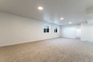 Carpeted empty room featuring recessed lighting