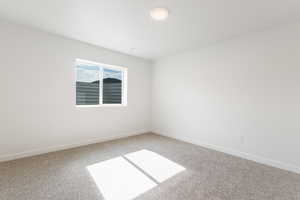Empty room with light colored carpet and baseboards