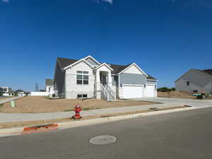 View of front facade featuring board and batten siding, driveway, and a residential view