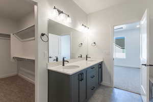 Full bathroom with baseboards and double vanity