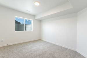 Spare room featuring carpet flooring and baseboards