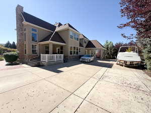 Traditional-style house featuring stone siding, stucco siding, a shingled roof, and driveway