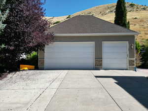Garage featuring concrete driveway and a mountain view