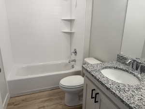 Full bathroom featuring  shower combination, vanity, and light wood finished floors