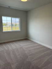 Empty room featuring carpet floors and baseboards