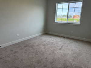 Carpeted empty room with baseboards