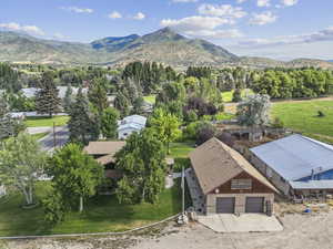 Aerial view of property and surrounding area featuring a mountainous background