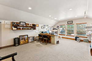 Carpeted home office featuring vaulted ceiling, rail lighting, and recessed lighting