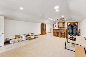 Home office with vaulted ceiling, a dry bar, recessed lighting, and light colored carpet