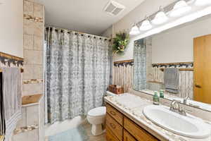 Full bathroom with vanity, shower / bathtub combination with curtain, and tile patterned floors