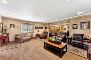 Living room featuring attic access, carpet flooring, recessed lighting, and a textured wall