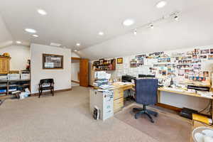 Carpeted office space featuring vaulted ceiling, recessed lighting, and rail lighting
