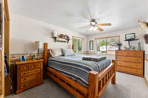 Carpeted bedroom featuring a textured ceiling and a ceiling fan