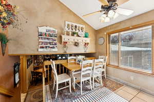 Dining room featuring vaulted ceiling, a ceiling fan, and tile patterned floors
