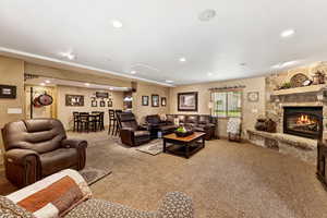 Living area featuring carpet, a stone fireplace, and recessed lighting