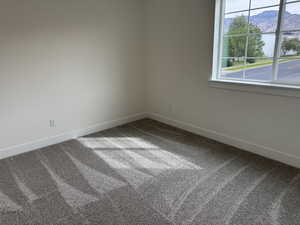 Carpeted spare room featuring baseboards and a mountain view
