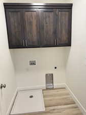 Laundry room featuring light wood finished floors, cabinet space, washer hookup, and hookup for an electric dryer