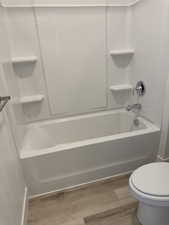 Full bathroom featuring light wood-style flooring and shower / washtub combination