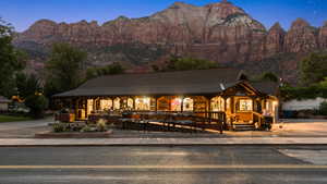 View of front facade featuring a porch, a mountain view, and a shingled roof
