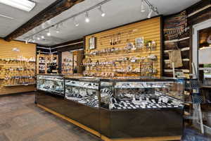 Community bar area with rail lighting, wood walls, and wood finished floors