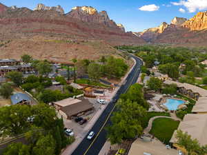 Aerial overview of property's location with a mountain backdrop and a pool area