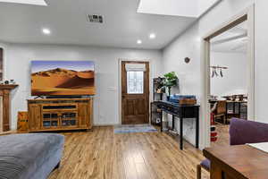 Foyer with wood finished floors, recessed lighting, and a skylight