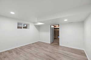 Finished below grade area featuring recessed lighting and light wood-style floors