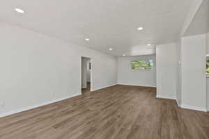 Spare room featuring a textured ceiling, recessed lighting, and wood finished floors