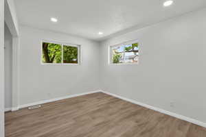 Unfurnished room featuring wood finished floors, recessed lighting, and a textured ceiling