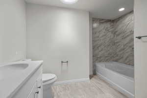 Full bath featuring vanity, shower / tub combination, marble finish flooring, and recessed lighting