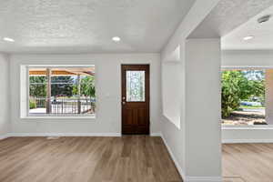 Foyer featuring a textured ceiling, wood finished floors, and recessed lighting