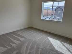 Unfurnished room with light colored carpet and a mountain view