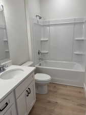 Full bathroom featuring light wood finished floors, washtub / shower combination, and vanity