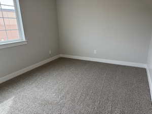 Unfurnished room featuring baseboards and carpet flooring