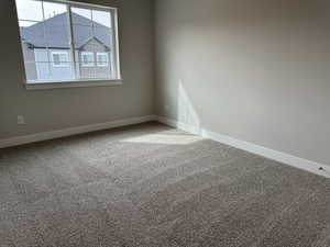 Empty room featuring carpet floors and baseboards