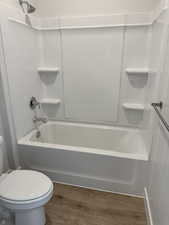 Bathroom featuring dark wood-style flooring and shower / bath combination