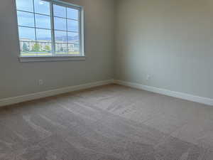 Carpeted spare room with a mountain view and baseboards