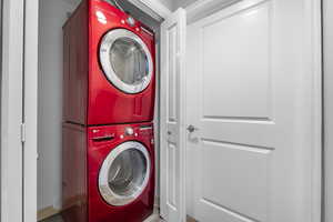 Laundry room featuring stacked washing machine and dryer