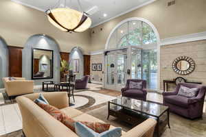 Lobby with crown molding, a towering ceiling, and recessed lighting
