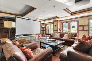 Home theater featuring a tray ceiling, ornamental molding, and recessed lighting