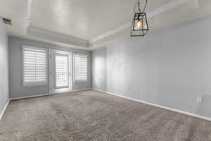 Carpeted spare room featuring a tray ceiling and crown molding