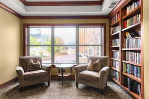 Living area with wall of books, a view of city, and ornamental molding
