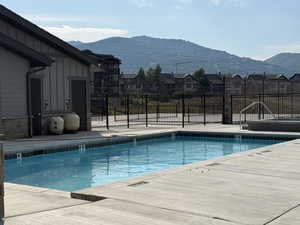 Community pool with a patio area, a mountain view, and a residential view