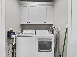 Washroom featuring washing machine and clothes dryer and cabinet space