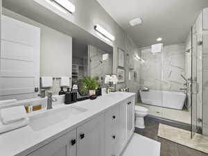 Bathroom with double vanity, a marble finish shower, tile patterned flooring, and recessed lighting