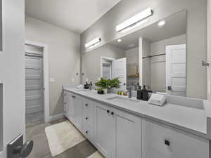 Bathroom featuring double vanity and finished concrete floors